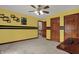 Bedroom featuring a fan, adjacent hallway, and light yellow paint scheme at 10814 Tallow Wood Ln, Indianapolis, IN 46236