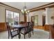 Formal dining room with classic wood trim, a large window, and an elegant chandelier at 10814 Tallow Wood Ln, Indianapolis, IN 46236