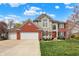 Beautiful two-story home featuring a brick and stone facade, three-car garage, and a well-manicured lawn at 10814 Tallow Wood Ln, Indianapolis, IN 46236