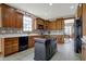 Charming kitchen featuring wood cabinets, tile backsplash, black center island and stainless steel appliances at 10814 Tallow Wood Ln, Indianapolis, IN 46236