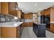 Charming kitchen featuring wood cabinets, tile backsplash, black center island and stainless steel appliances at 10814 Tallow Wood Ln, Indianapolis, IN 46236
