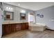 Main bathroom featuring double sinks, soaking tub, and wood-look flooring at 10814 Tallow Wood Ln, Indianapolis, IN 46236