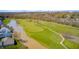 Picturesque aerial view of a golf course alongside a calm lake, showcasing meticulously maintained green fairways at 10846 Hamilton Pass, Fishers, IN 46037