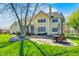 Expansive backyard featuring a brick patio with seating, a lush lawn, mature trees, and multi-level deck at 10846 Hamilton Pass, Fishers, IN 46037