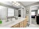 Bright bathroom featuring double sinks with wood cabinets and a view into the next bedroom at 10846 Hamilton Pass, Fishers, IN 46037