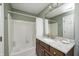 Well-lit bathroom with a granite countertop vanity and shower and tub with white tiled walls at 10846 Hamilton Pass, Fishers, IN 46037