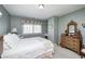 Comfortable bedroom featuring a decorative dresser, carpet and a large window with floral valance at 10846 Hamilton Pass, Fishers, IN 46037