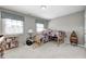 Neutral bedroom with two beds, a bookshelf, two windows and light grey walls and carpet at 10846 Hamilton Pass, Fishers, IN 46037