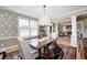 Elegant dining room with patterned wallpaper, hardwood floors, and a decorative chandelier at 10846 Hamilton Pass, Fishers, IN 46037