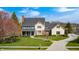 Well-manicured lawn and mature trees enhance the curb appeal of this classic home with a welcoming porch at 10846 Hamilton Pass, Fishers, IN 46037