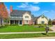 Charming two-story home with yellow siding, green shutters, brick accents, and a well-manicured lawn at 10846 Hamilton Pass, Fishers, IN 46037