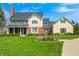 Beautiful two-story home with a welcoming front porch, complemented by a well-maintained lawn and lush landscaping at 10846 Hamilton Pass, Fishers, IN 46037