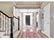 Spacious foyer featuring a black front door, hardwood floors, staircase, and column details at 10846 Hamilton Pass, Fishers, IN 46037
