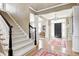Grand foyer with staircase, hardwood floors, and columns, offering a view into the dining area at 10846 Hamilton Pass, Fishers, IN 46037