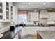 Well-lit kitchen with custom white cabinetry and black countertops at 10846 Hamilton Pass, Fishers, IN 46037