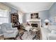 Cozy living room featuring a fireplace, hardwood floors, and comfortable seating arrangement at 10846 Hamilton Pass, Fishers, IN 46037