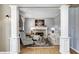 Comfortable living room featuring a fireplace, hardwood floors, and elegant columns at 10846 Hamilton Pass, Fishers, IN 46037