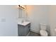 Bathroom showcasing a toilet and vanity with a mirror, accented by modern lighting at 10880 N 23Rd St, Elwood, IN 46036