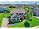 Aerial view of a beautiful suburban home featuring lush landscaping, a basketball court, and mature trees at 11509 Wildlife Ct, Zionsville, IN 46077