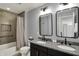 Nicely decorated bathroom with double sinks, granite counter, shower, and two mirrors at 11509 Wildlife Ct, Zionsville, IN 46077