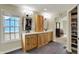 Bright bathroom featuring dual sink vanities, modern light fixtures, and a closet with custom shelving at 11509 Wildlife Ct, Zionsville, IN 46077