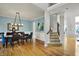 Elegant dining room with hardwood floors, modern light fixture, and staircase views at 11509 Wildlife Ct, Zionsville, IN 46077