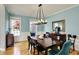 Stylish dining room featuring hardwood floors, a modern chandelier, and a large dining table at 11509 Wildlife Ct, Zionsville, IN 46077