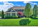 Charming two-story home with a well-manicured lawn, lush landscaping, and a brick facade at 11509 Wildlife Ct, Zionsville, IN 46077