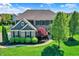 Attractive two-story home with lush green lawn, mature trees, and basketball hoop in the driveway at 11509 Wildlife Ct, Zionsville, IN 46077
