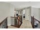 Carpeted second-floor hallway with wood railing overlooking foyer at 11509 Wildlife Ct, Zionsville, IN 46077
