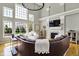 Stunning living room boasts soaring ceilings, large windows, a stone fireplace, and a plush sectional sofa at 11509 Wildlife Ct, Zionsville, IN 46077