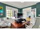Bright and modern home office featuring white trim, french doors, a wooden desk, and views of the landscaped yard at 11509 Wildlife Ct, Zionsville, IN 46077