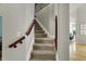 Carpeted stairway with wood railing leads to the upper level at 11509 Wildlife Ct, Zionsville, IN 46077