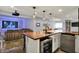 Basement wet bar with wood countertop, stainless appliances, beverage cooler, sink and view into the seating area with projector at 11509 Wildlife Ct, Zionsville, IN 46077