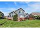 Expansive backyard showcases a manicured lawn, a wooden deck, and a patio, complemented by mature landscaping and home's siding at 11685 Platt St, Noblesville, IN 46060