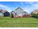 Lush backyard boasts a pristine lawn, a wooden deck, and a patio with seating, framed by the home's attractive blue exterior at 11685 Platt St, Noblesville, IN 46060