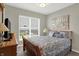 Comfortable bedroom features a window with blinds, soft decor, and hardwood furniture at 11685 Platt St, Noblesville, IN 46060