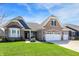 Inviting brick home featuring a well-manicured lawn and a spacious three-car garage, set under a bright, blue sky at 11685 Platt St, Noblesville, IN 46060
