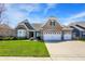Charming brick home boasts a three-car garage and lush green lawn, perfect for suburban living under a bright sky at 11685 Platt St, Noblesville, IN 46060