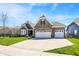 Brick home with a manicured lawn, showcases a three-car garage, and a spacious driveway, perfect for a growing Gathering at 11685 Platt St, Noblesville, IN 46060