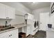 Functional laundry room with sink, cabinetry, and modern washer and dryer at 11685 Platt St, Noblesville, IN 46060