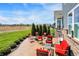 Beautiful stamped concrete patio with a fire pit, mature landscaping, and comfortable red seating for outdoor gatherings at 11685 Platt St, Noblesville, IN 46060