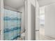 Bathroom featuring a blue patterned shower curtain, toilet, and open doorway at 12894 Corydon Dr, Fishers, IN 46037