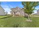 Manicured lawn featuring mature tree in front of this two-story home with mixed siding at 12894 Corydon Dr, Fishers, IN 46037