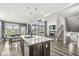 Open-concept kitchen with island seating area, stainless steel dishwasher, and adjacent living space at 12894 Corydon Dr, Fishers, IN 46037