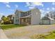 Exterior view of a two-story home with a gravel driveway and a detached garage at 13 N Main St, Brooklyn, IN 46111