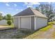 Detached one-car garage with gray siding, gray garage door and side entrance at 13 N Main St, Brooklyn, IN 46111
