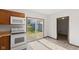 Well-lit kitchen features wood cabinets, white appliances, and sliding glass doors at 13 N Main St, Brooklyn, IN 46111