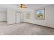 Bright living room features neutral carpet, two windows and a white door at 13 N Main St, Brooklyn, IN 46111
