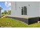 Exterior shot showcasing the concrete patio and sliding glass door, complemented by well-maintained siding and lighting at 13 N Main St, Brooklyn, IN 46111